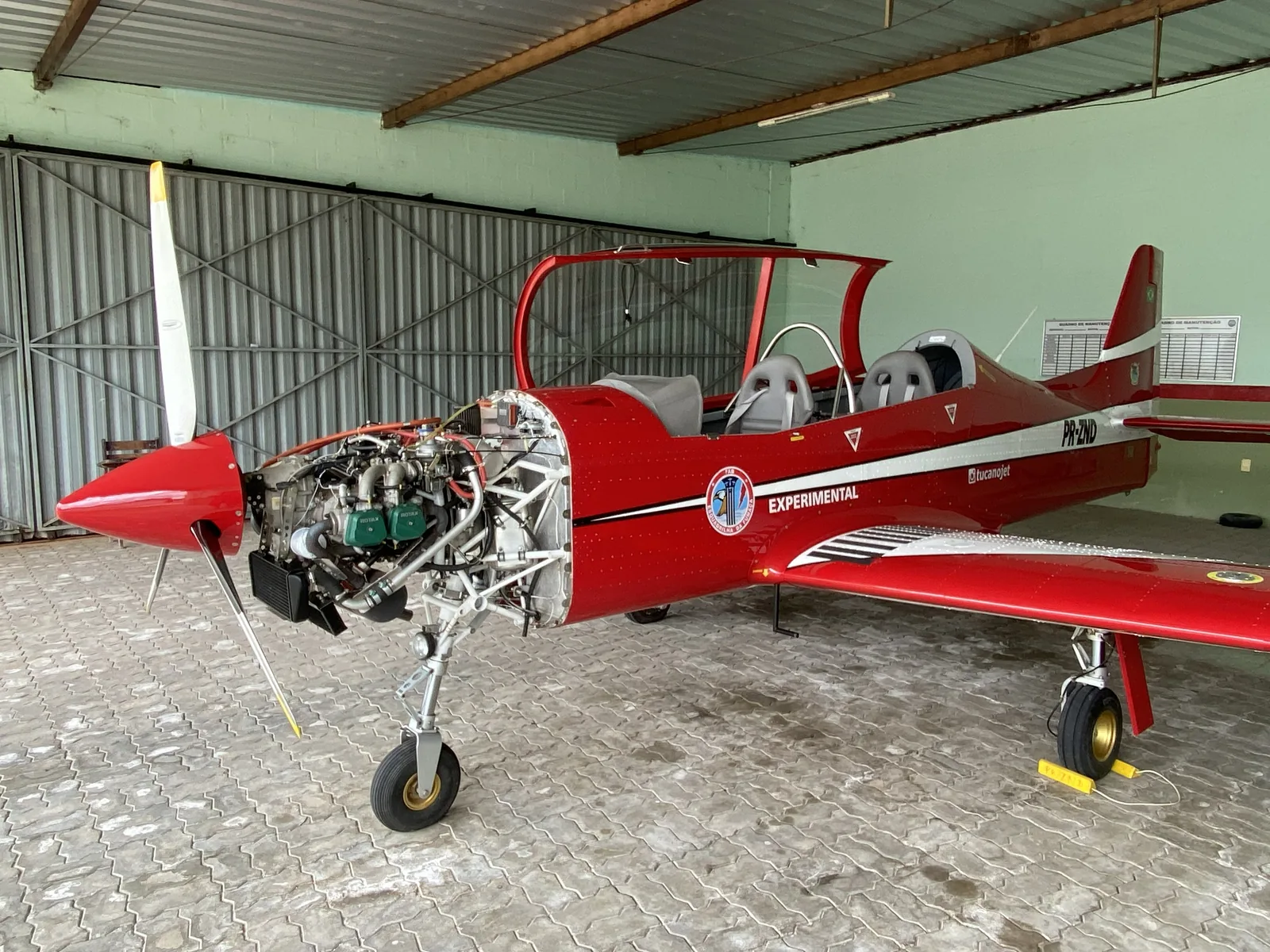 The aircraft in the hangar with the engine cowling removed during modernization